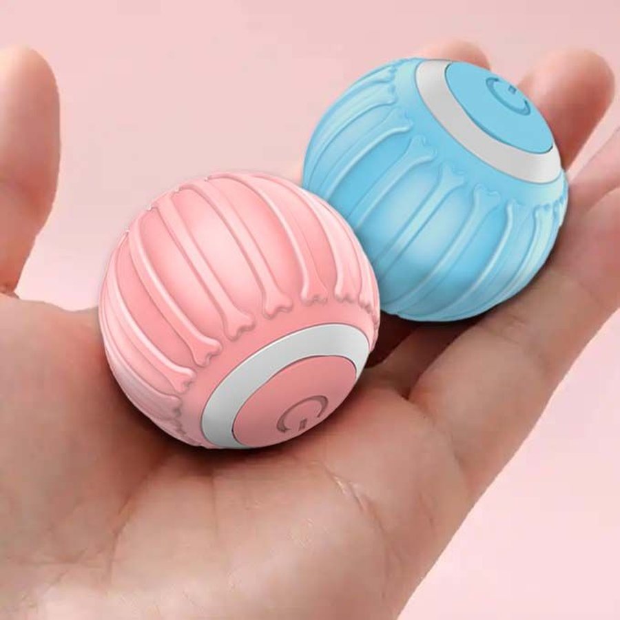 Pink and blue cat balls held in one hand to show the size